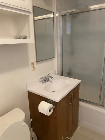 a bathroom with a sink vanity mirror and toilet