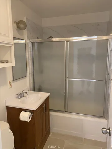 a bathroom with a sink vanity and shower