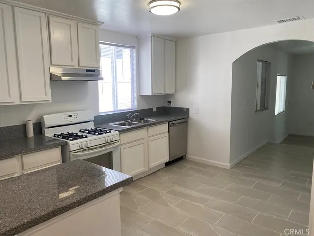a kitchen with granite countertop a stove and a sink