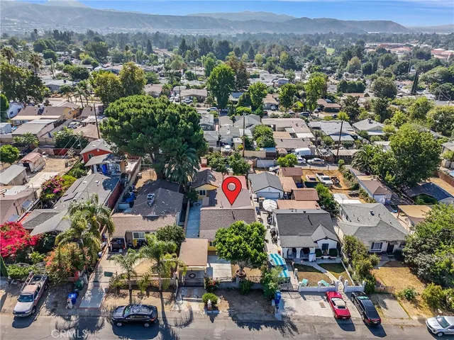 a view of a house with a tree and flower plants