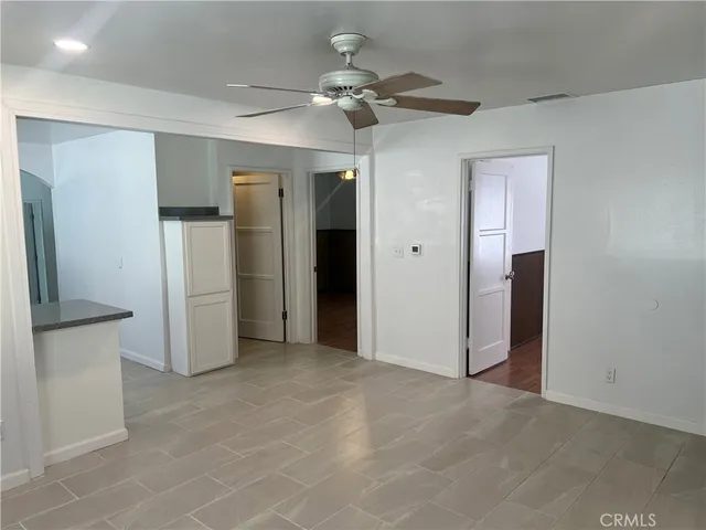 an empty room with closet and a chandelier fan