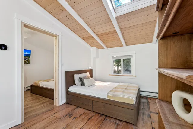 a bedroom with a bed and wooden floor