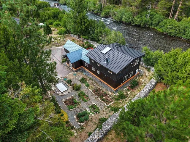 an aerial view of a house with a yard and large trees