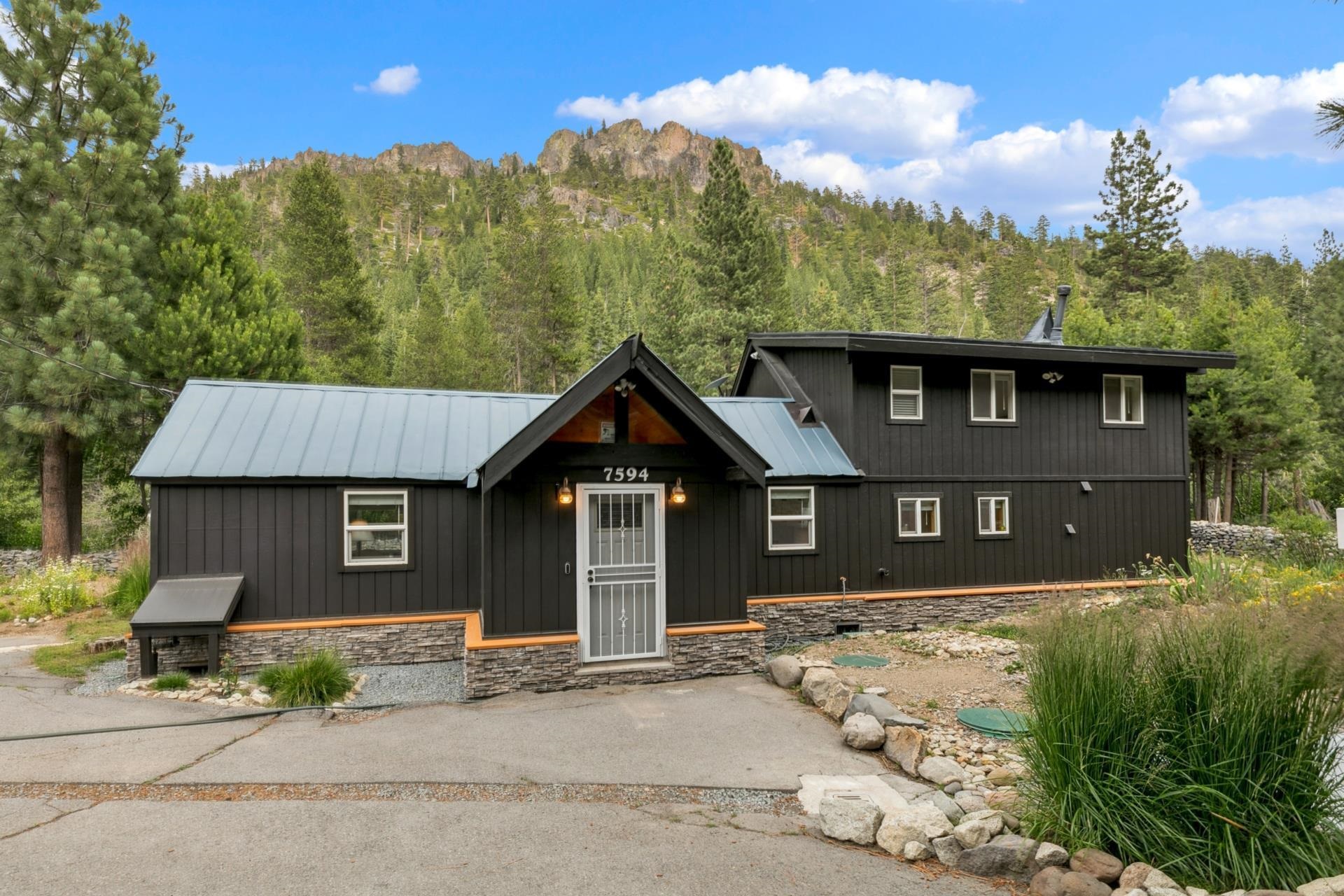 7594-7598 River Road Truckee, CA 96161 - Photo 3 of 27 a front view of a house with a garden and trees