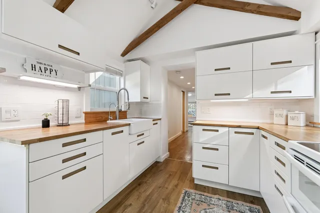 a kitchen with granite countertop white cabinets and white appliances