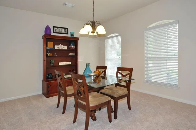 a view of a dining room with furniture and chandelier