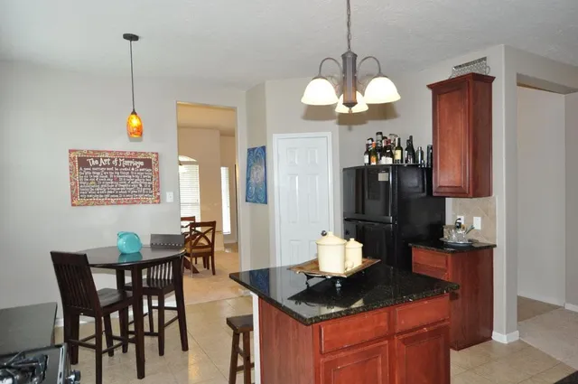a kitchen with a stove a sink and a wooden cabinets