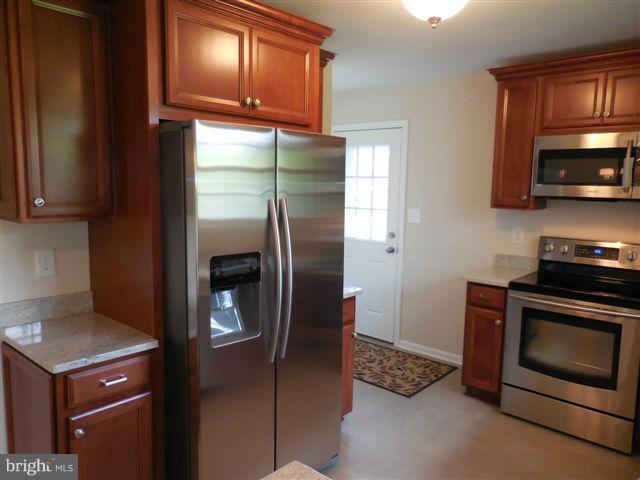 517 Shipley Road Linthicum, MD 21090 - Photo 9 of 30 a kitchen with stainless steel appliances granite countertop a refrigerator a stove and a sink with wooden floor