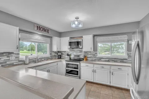 a kitchen with a sink window and cabinets