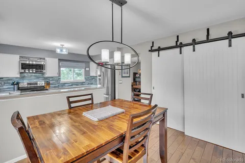 a kitchen with stainless steel appliances kitchen island a table and chairs in it