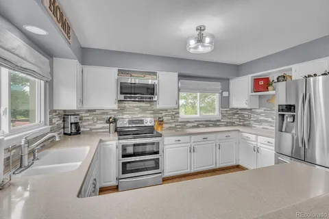 a kitchen with stainless steel appliances a stove sink and microwave
