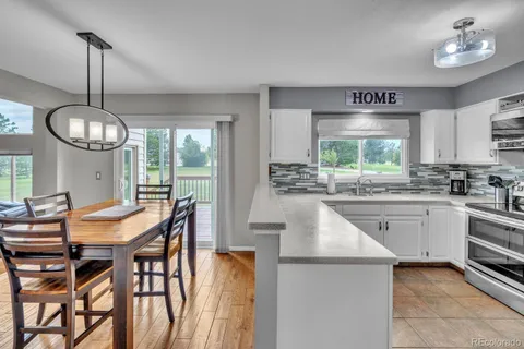 a kitchen with stainless steel appliances kitchen island a table and chairs in it