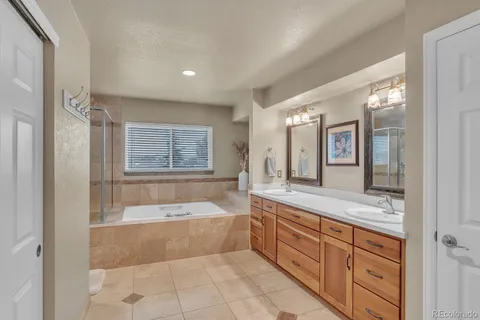 a spacious bathroom with a tub sink and mirror