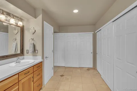 a spacious bathroom with a granite countertop sink a mirror and a shower
