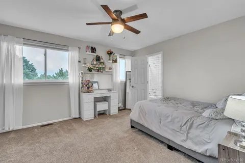 a bedroom with a bed and a large window