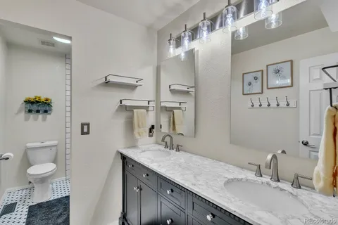 a bathroom with a granite countertop sink mirror and toilet