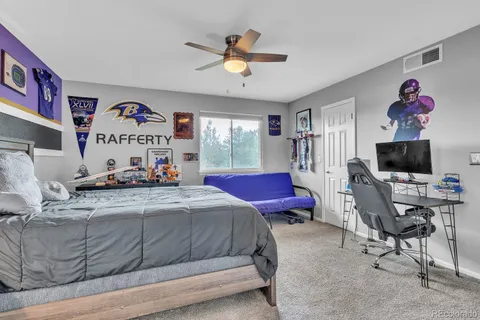 a bedroom with a bed a couch and a flat screen tv