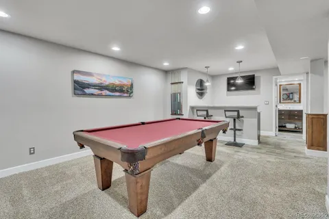 a room with furniture pool table and window