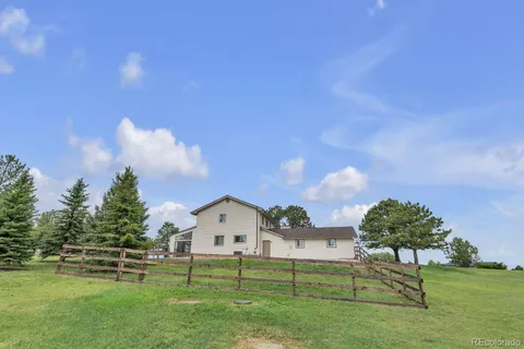 a view of a house with a big yard and a large tree
