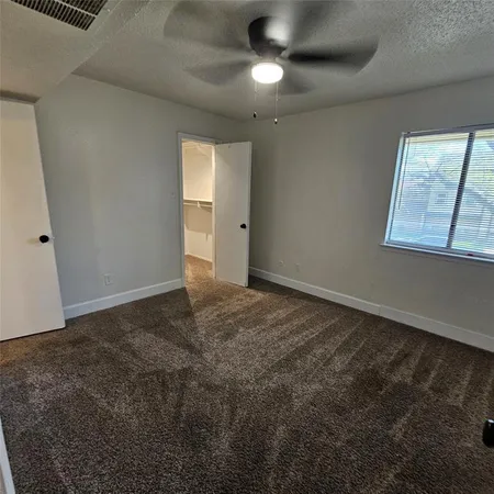 a view of a hallway with wooden floor and a bathroom