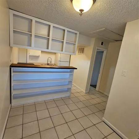 a view of a room with wooden floor and cabinets