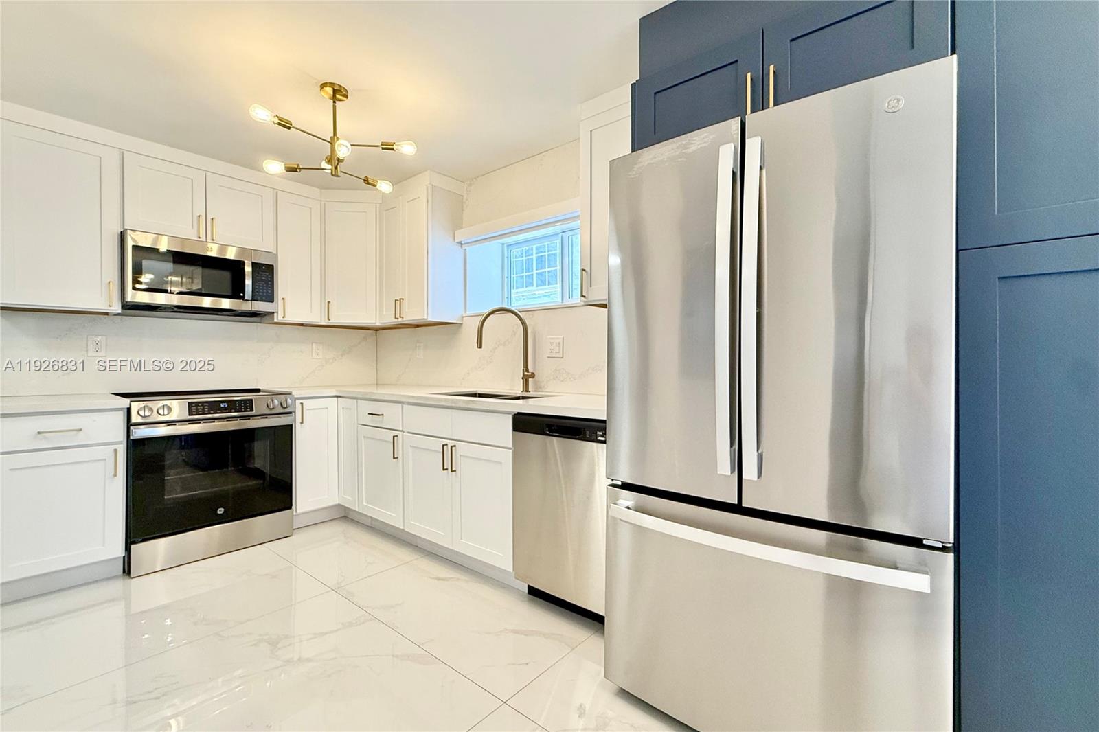 4122 Collins Avenue, Unit 2B Miami Beach, FL 33140 - Photo 2 of 13 a kitchen with stainless steel appliances a refrigerator sink and microwave