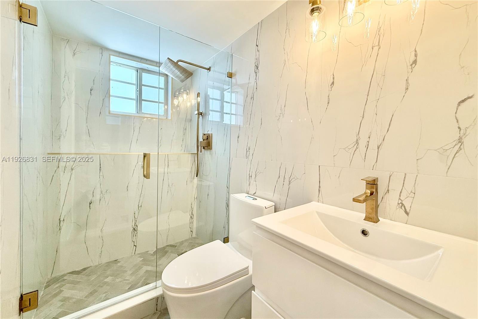 4122 Collins Avenue, Unit 2B Miami Beach, FL 33140 - Photo 10 of 13 a bathroom with a sink a toilet and shower