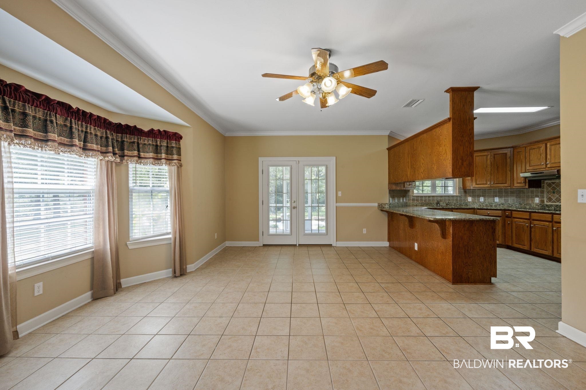 5618 Leytham Road Theodore, AL 36582 - Photo 22 of 60 Kitchen with ceiling fan, kitchen peninsula, backsplash, light tile patterned floors, and a kitchen breakfast bar