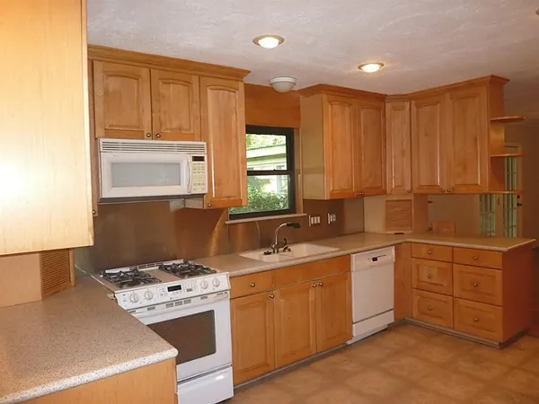 a kitchen with a stove sink and cabinets