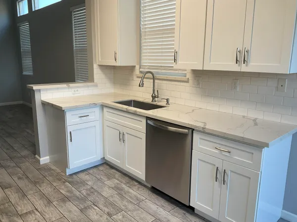 a kitchen with stainless steel appliances granite countertop a sink stove and cabinets