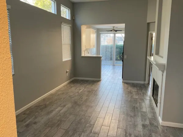 a view of a hallway with wooden floor and windows
