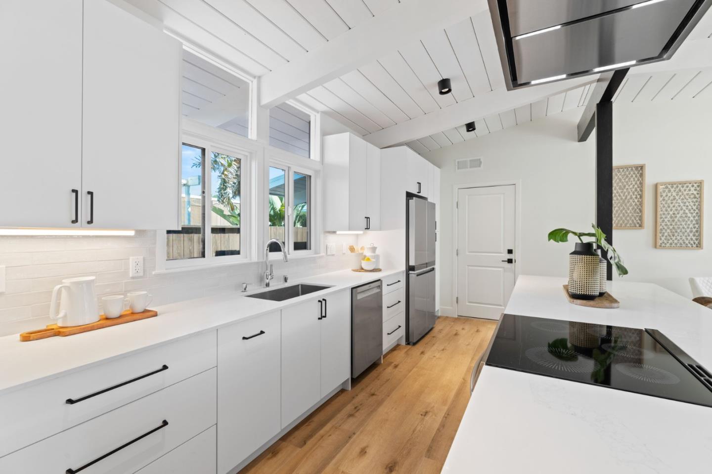 1734 Wolfe Drive San Mateo, CA 94402 - Photo 9 of 43 a kitchen with a sink dishwasher and white cabinets with wooden floor