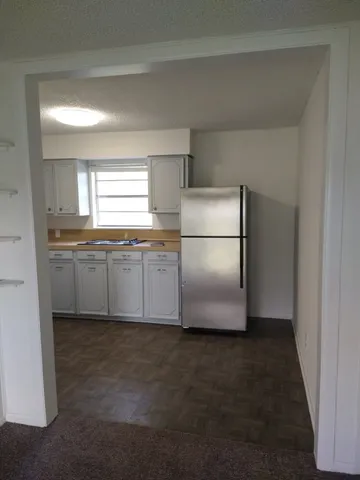a kitchen with cabinets a refrigerator and a sink
