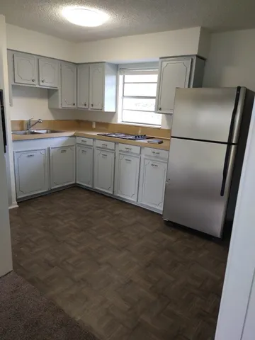 a kitchen with cabinets and white stainless steel appliances