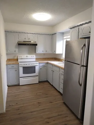 a kitchen with stainless steel appliances granite countertop a refrigerator sink and stove