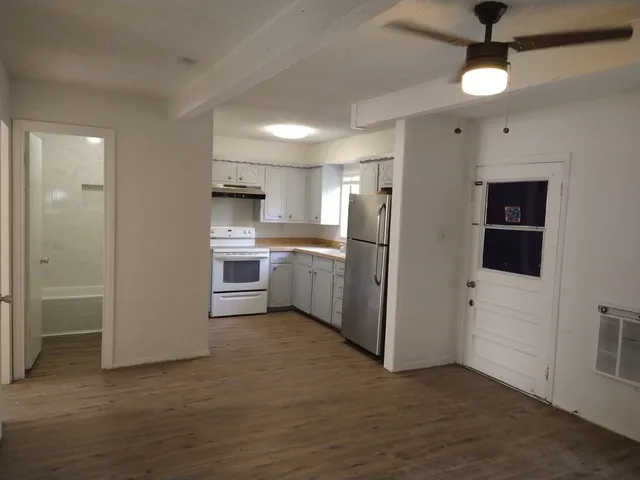 a view of a kitchen with refrigerator and white cabinets