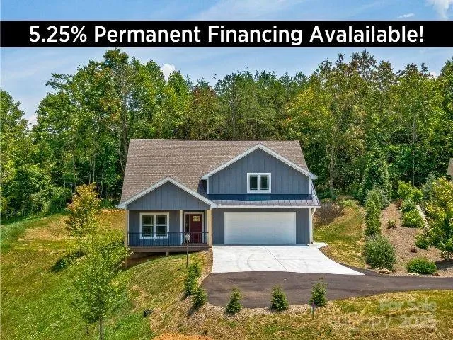 a sign that is sitting in front of a house with potted plants