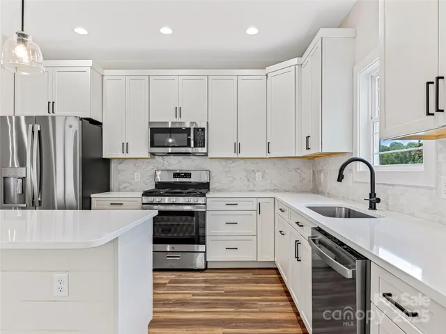 a kitchen with stainless steel appliances granite countertop a sink stove and refrigerator