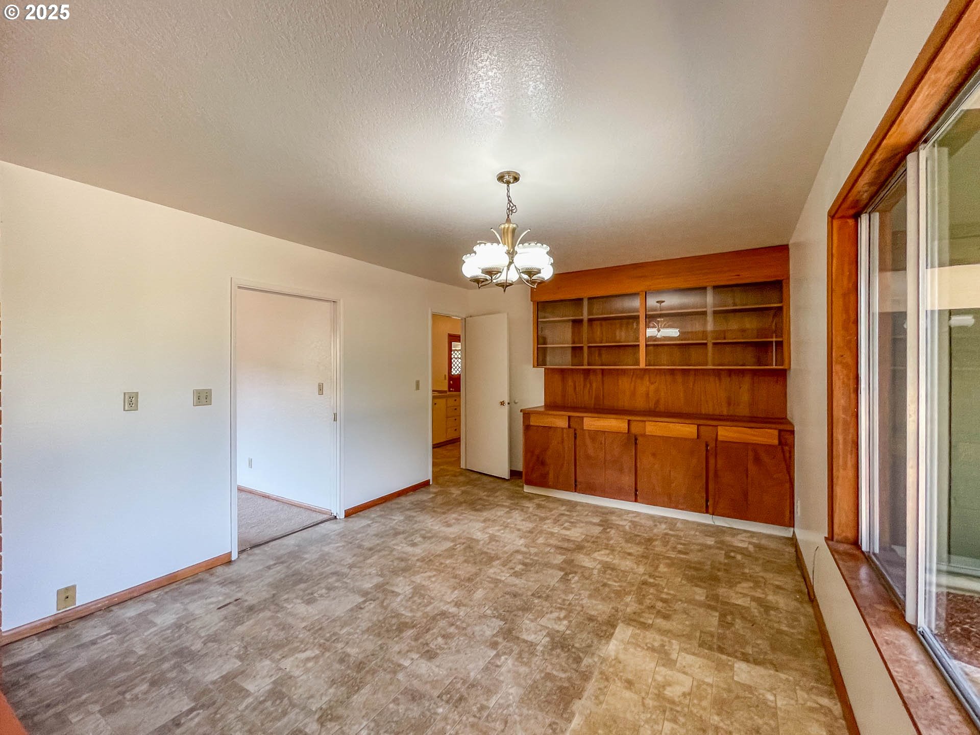 765 O C Brown Road Roseburg, OR 97470 - Photo 9 of 48 en empty room with a fireplace and chandelier