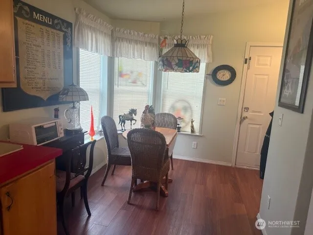 a view of a dining room with furniture a chandelier and wooden floor