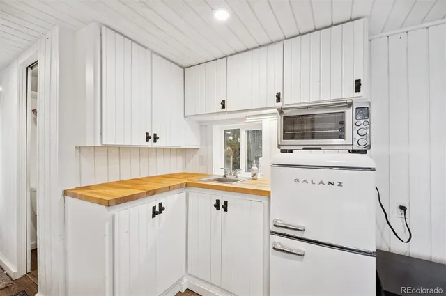 a kitchen with white cabinets and white appliances