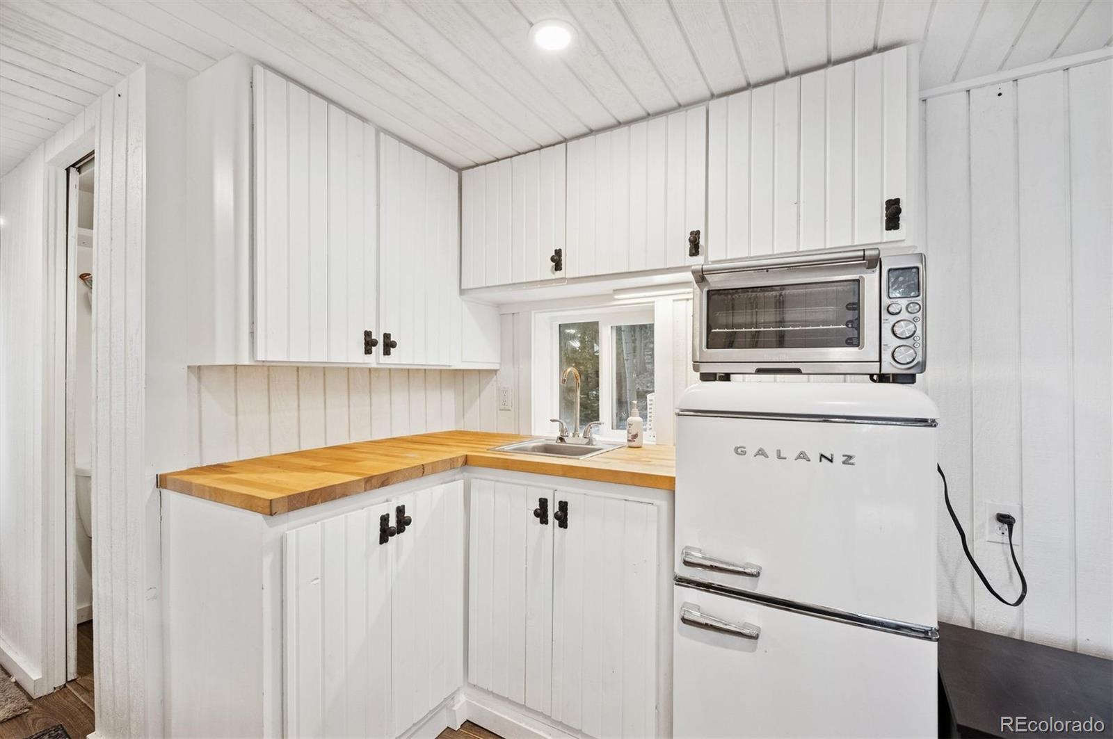 2334 Sinton Road Evergreen, CO 80439 - Photo 5 of 28 a kitchen with white cabinets and white appliances