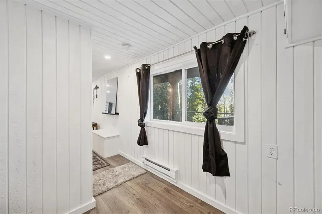 a view of a hallway with wooden floor and entryway
