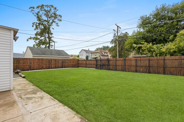 a view of a backyard with wooden fence