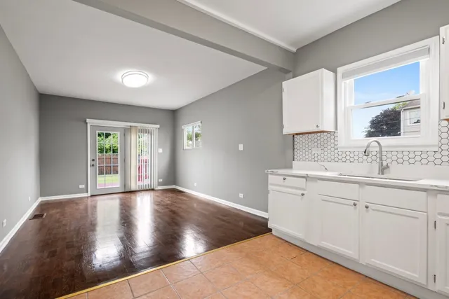 a view of an empty room with window and bathroom