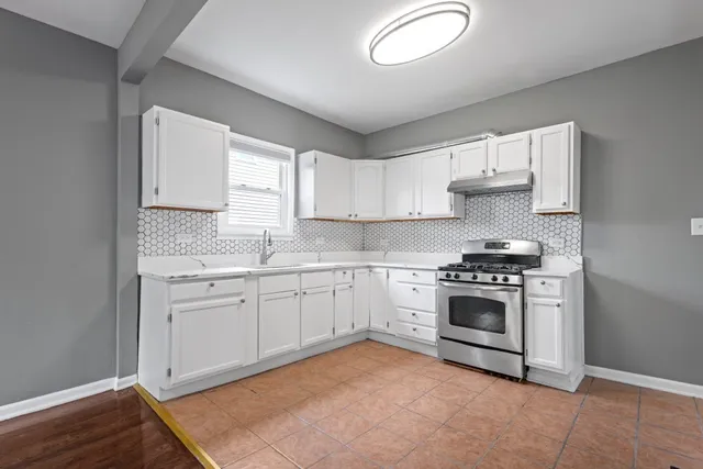 a kitchen with granite countertop a stove a sink and a microwave