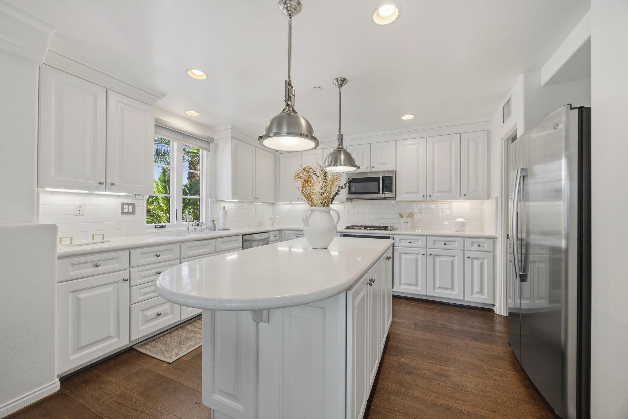 218 Santa Barbara Street, Unit D Santa Barbara, CA 93101 - Photo 8 of 25 a kitchen with kitchen island granite countertop a sink a counter space appliances and cabinets