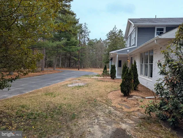 a view of a house with backyard and trees