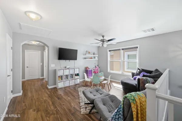 a living room with furniture a flat screen tv and a floor to ceiling window