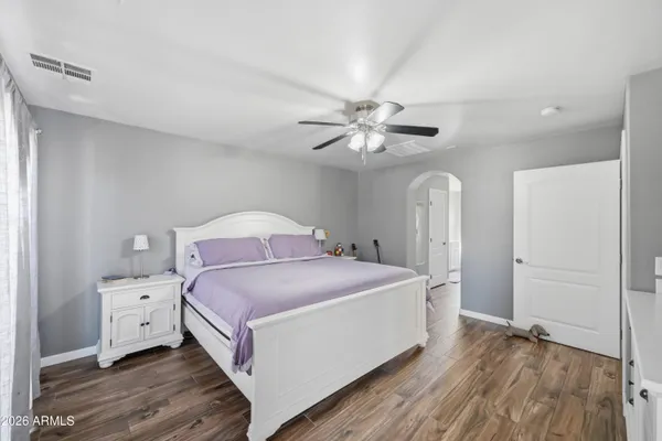 a spacious bedroom with a bed and a chandelier